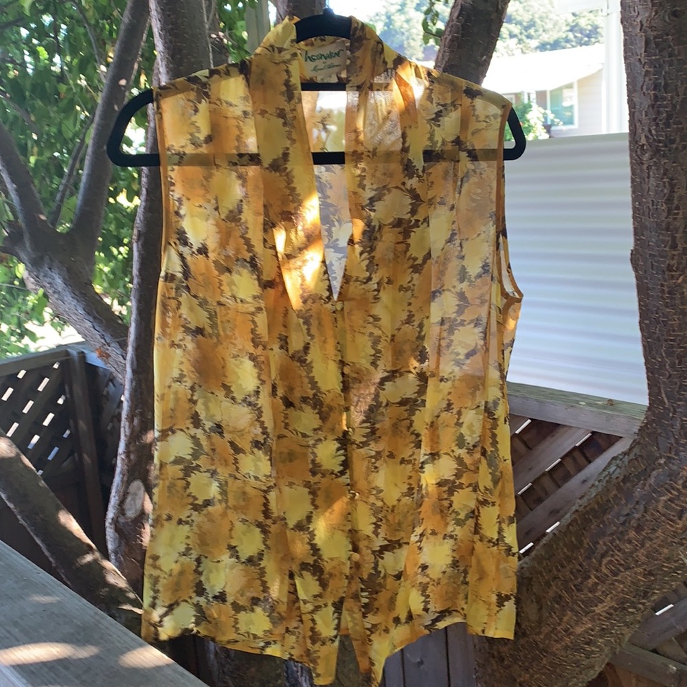 Sleeveless silk blouse with covered buttons.